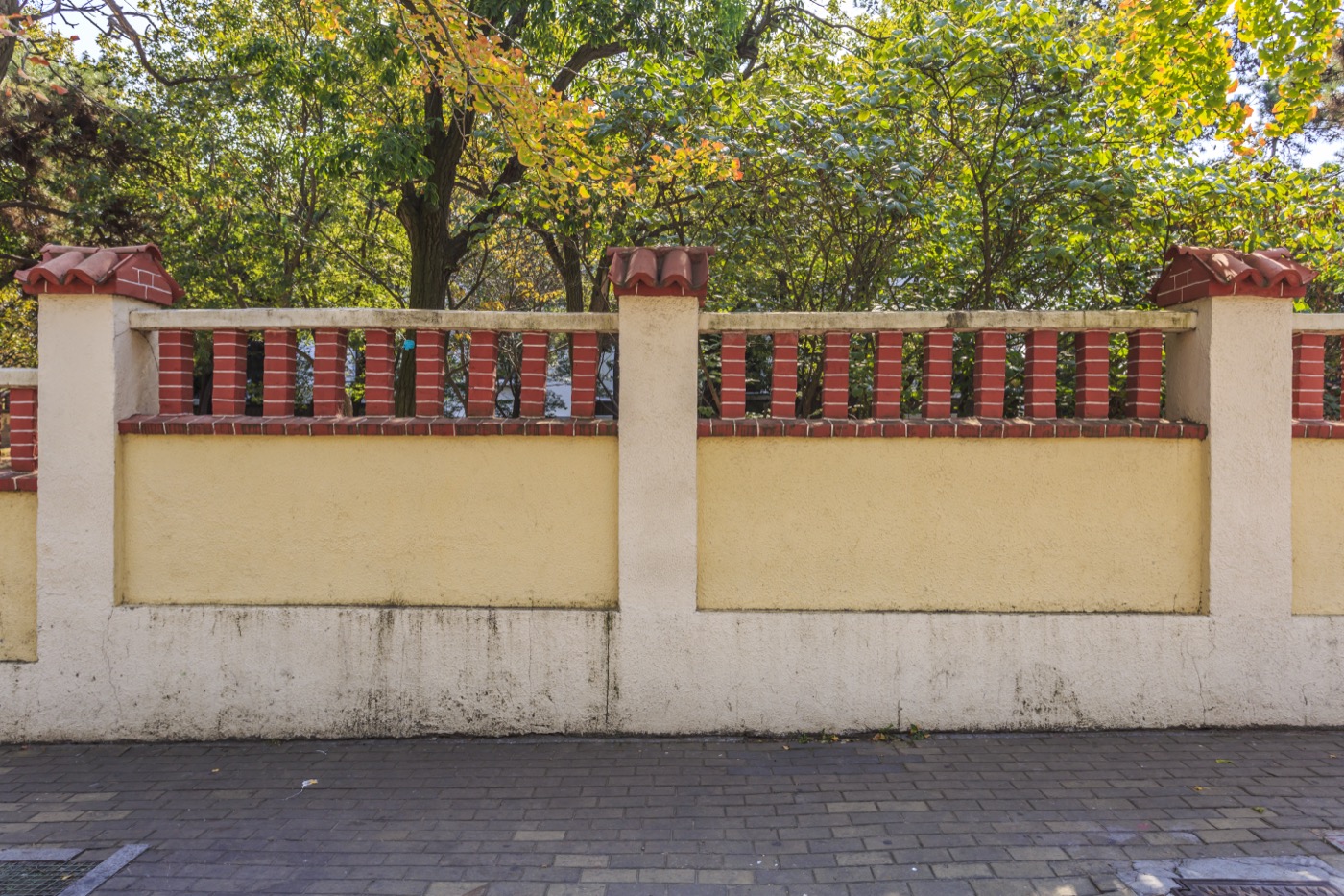 Brick and plaster compound wall construction in Bangalore with a decorative design